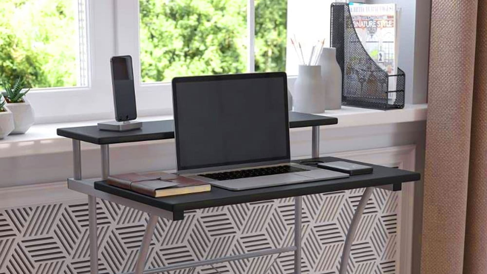 Metal desk with a laptop, a mobile phone and some accessories on it