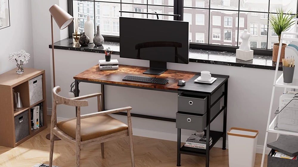 Secretary desk with two drawers and a shelf. On it there is a monitor, a keyboard, a mouse and other common elements in a workspace.