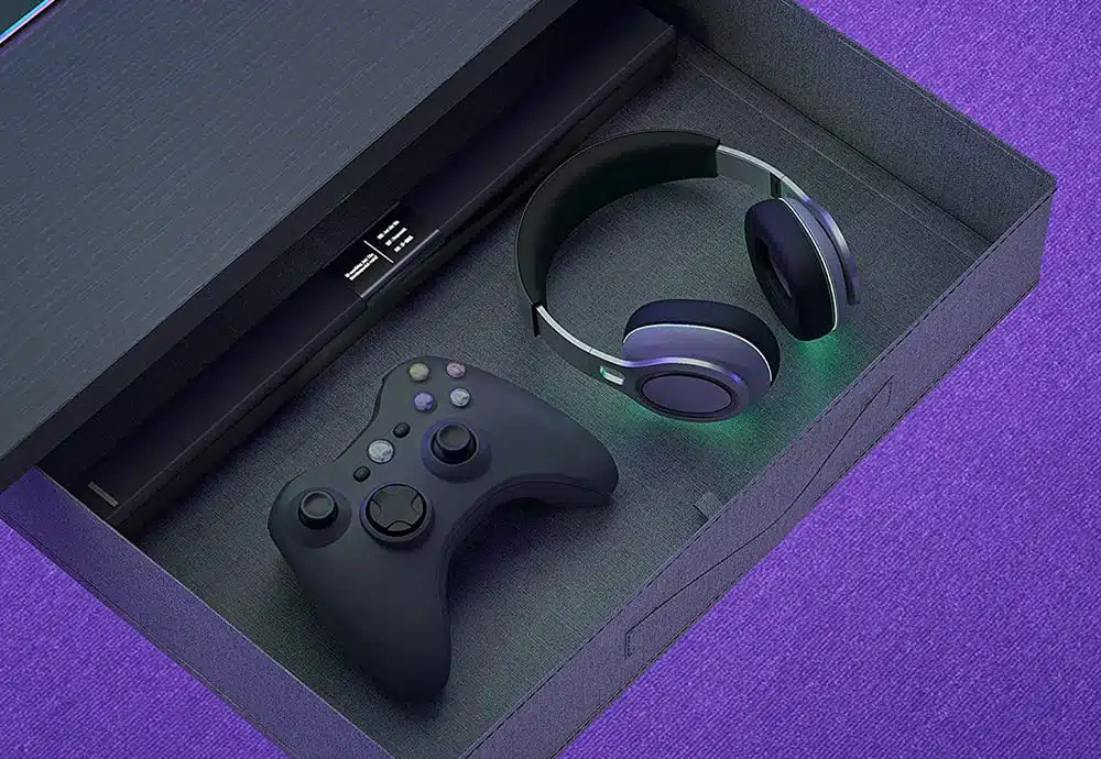 Drawer of the CubiCubi L-shaped gaming desk. Inside there is a headset, a game controller and a sound bar.